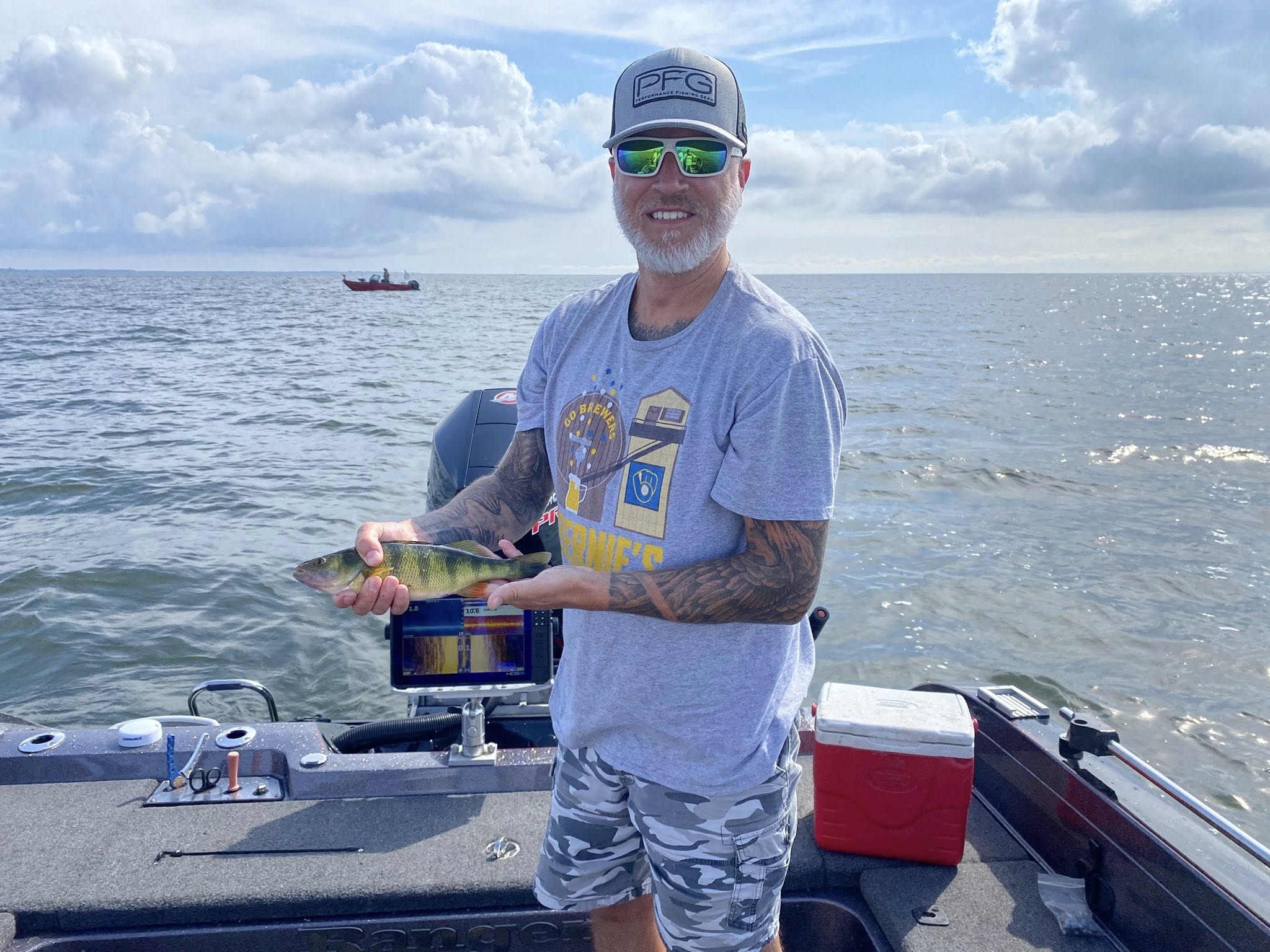 Client holding a perch on the boat during a guided fishing trip
