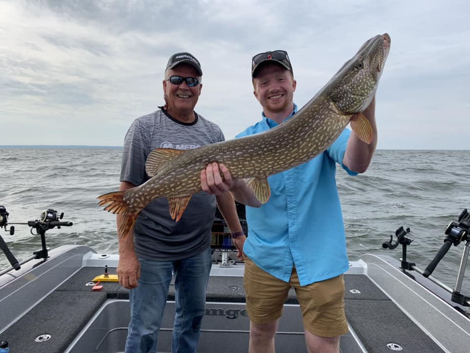 Wayne Butz and his son holding a large northern pike
